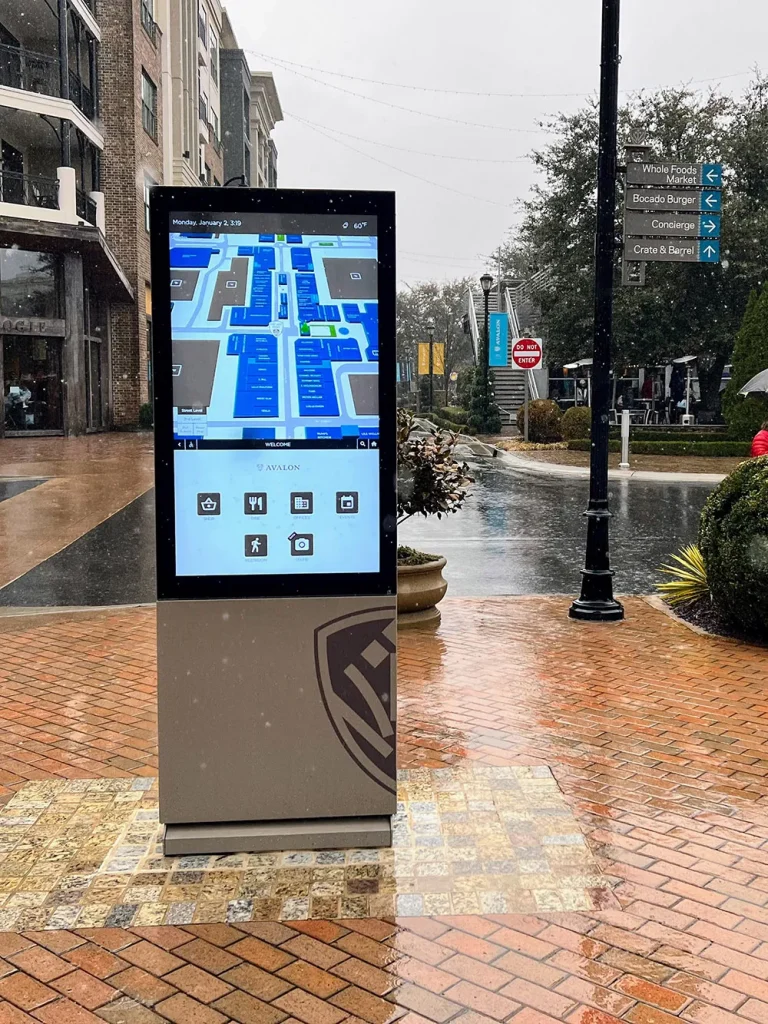 A bright digital display in a rainy township street and grey skies