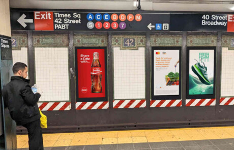 5 panels on a subway wall - 3 are digital displays