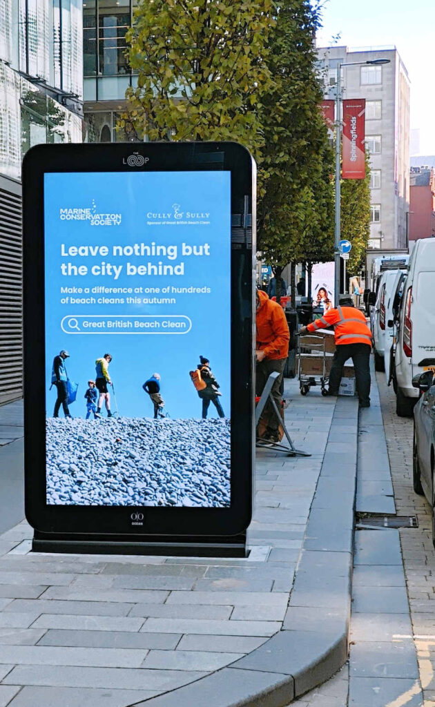 A bright blue advertisement on an outdoor LCD screen in a city setting