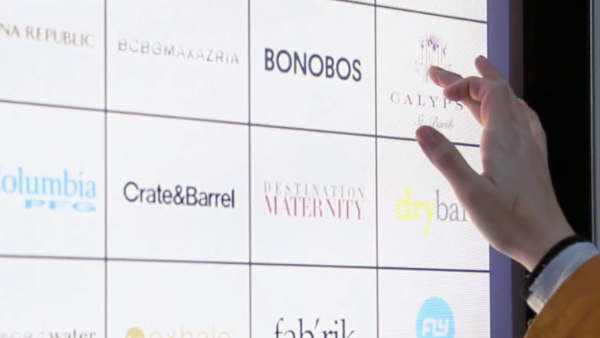Close-up of a hand touching a tiled touchscreen with brand logos