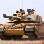 A tan tank on top of sand/dirt