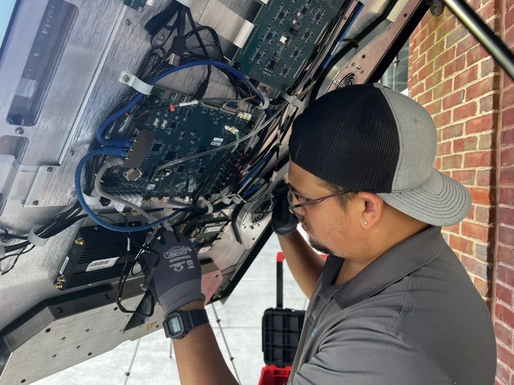 BoldVu technician tending to a wall mounted display